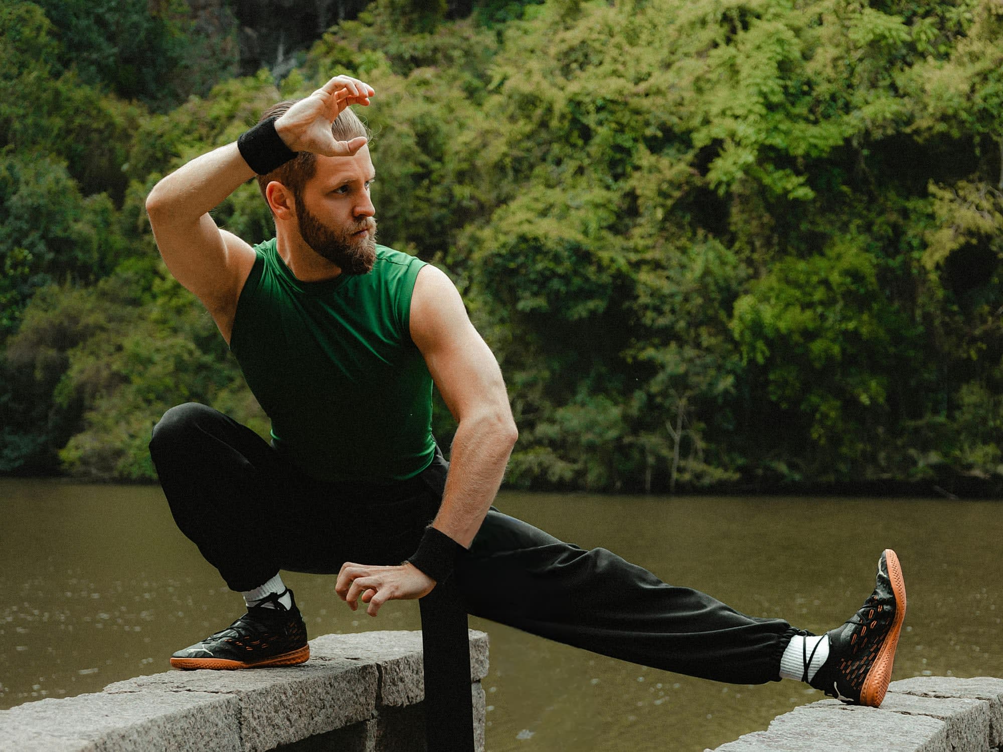 A martial artist in a low kung-fu stance beside a river